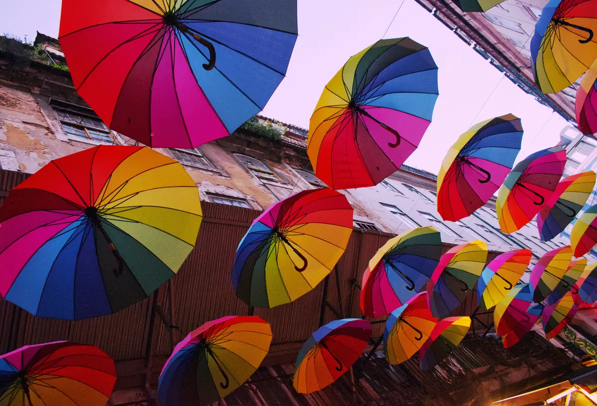 Rainbow umbrellas suspended above Pink Street in Lisbon